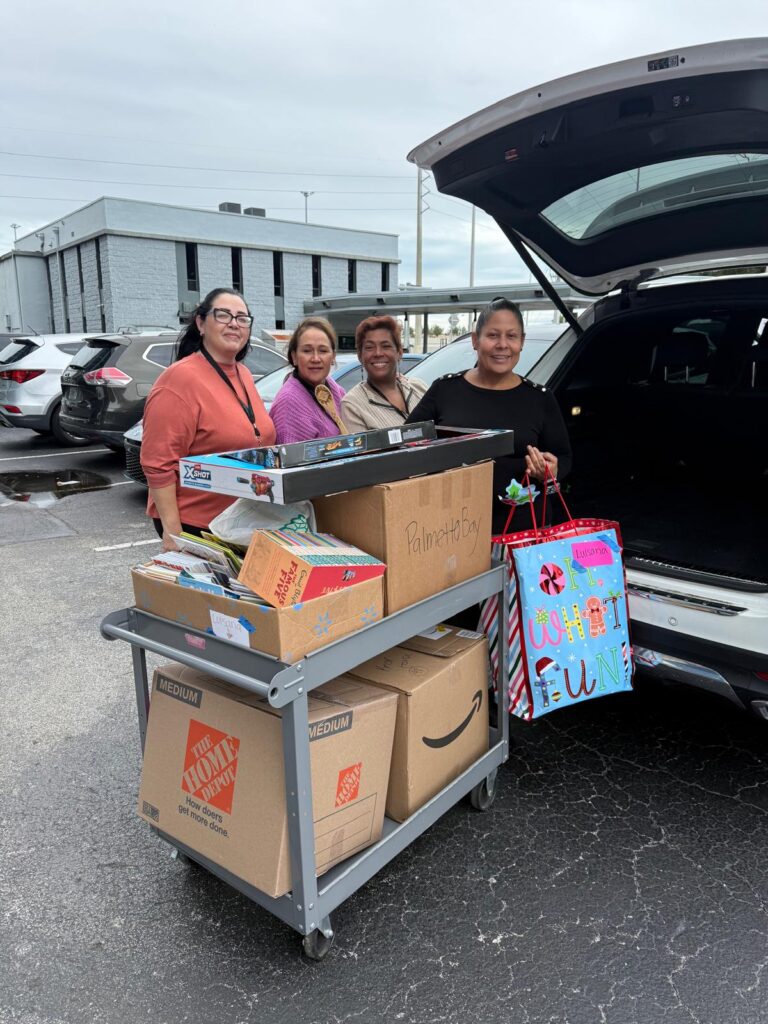 Equipo de Bridging Families and Communities recibiendo los donativos de juguetes de Unidos en la Misión 